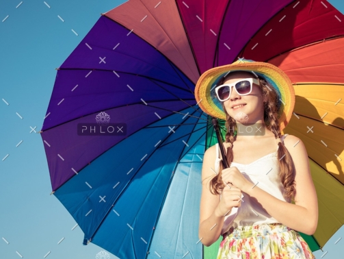 teen-girl-with-umbrella-standing-on-the-beach-at-PMEQ6S8